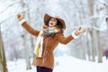 Happy stylish female rejoicing outdoors in city park in winter