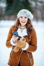 Happy stylish female sending text message using smartphone Royalty Free Stock Photo