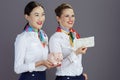 happy stylish flight attendant women isolated on gray Royalty Free Stock Photo