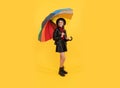 happy stylish girl in leather wear. cheerful teen child hold colorful parasol. kid in hat Royalty Free Stock Photo