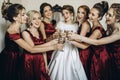 Happy stylish gorgeous blonde bride with bridesmaids on the back