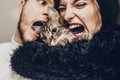 happy stylish hipster family hugging with their cat. man and woman holding kitty and having fun and taking selfie, happy family m Royalty Free Stock Photo