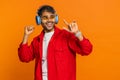 Happy stylish Indian man in sunglasses listening music via headphones, dancing disco having fun Royalty Free Stock Photo