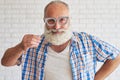 Happy stylish man is trying grey paper glasses