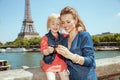 Happy stylish mother and daughter travellers viewing photos