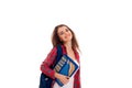 Happy stylish smart student girl with backpack on her shoulders and folders for notebooks in hands posing and smiling on Royalty Free Stock Photo