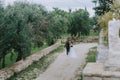 Happy stylish smiling couple walking in Tuscany, Italy on their wedding day. The bride and groom walk down the street by Royalty Free Stock Photo