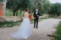 Happy stylish smiling couple walking in Tuscany, Italy on their wedding day. The bride and groom walk down the street by Royalty Free Stock Photo