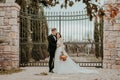 Happy stylish smiling couple walking in Tuscany, Italy on their wedding day. The bride and groom walk down the street by Royalty Free Stock Photo