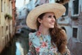 Happy stylish tourist woman in floral dress sightseeing