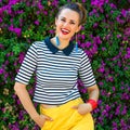 Happy stylish woman against colorful magenta flowers bed Royalty Free Stock Photo