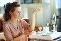 Happy stylish woman applying moisturiser on elbow Royalty Free Stock Photo