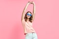 Happy stylish woman in cool sunglasses with hands up posing on pink Royalty Free Stock Photo