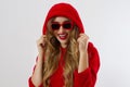 Happy stylish young woman in red hoodie, sunglasses isolated on white background. Close-up girl smiling face. Fashion and beauty Royalty Free Stock Photo