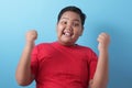 Happy success fat Asian boy shows winning gesture Royalty Free Stock Photo