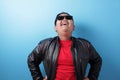 Happy success fat Asian boy wearing leather jacket and sunglasses shows winning gesture Royalty Free Stock Photo