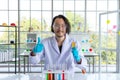 Happy success scientist doctor showing thumbs up and holding test tube in research laboratory Royalty Free Stock Photo