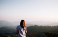 Happy success woman at sunset or sunrise standing at mountain