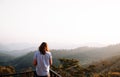 Happy success woman at sunset or sunrise standing at mountain