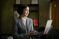 A happy Asian businesswoman leaning on her table and using her portable laptop computer Royalty Free Stock Photo