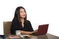 Happy successful Asian Chinese business woman working relaxed at office computer desk smiling thoughtful and sweet in success and Royalty Free Stock Photo