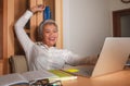 Happy and successful attractive middle aged Asian woman working at office laptop computer desk excited and cheerful celebrating Royalty Free Stock Photo