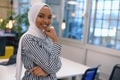 Happy successful business leader posing while her team in background. Young African American business woman standing  and smiling Royalty Free Stock Photo