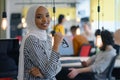 Happy successful business leader posing while her team in background. Young African American business woman standing  and smiling Royalty Free Stock Photo