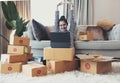 Happy successful business woman with arms up working with laptop and cardboard box on table in home office. business online and Royalty Free Stock Photo