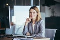Happy and successful business woman boss working at computer in modern office looking at camera and smiling Royalty Free Stock Photo