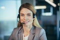 Happy and successful business woman looking at camera and smiling female worker with headset for video call, close up portrait Royalty Free Stock Photo