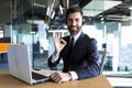 successful call center employee looks at the camera and smiles, businessman keeps his finger approvingly up, working at Royalty Free Stock Photo