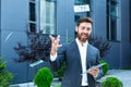 Happy successful Caucasian bearded businessman counts, waves, throws, show off, flaunt cash money background a modern office Royalty Free Stock Photo