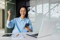 Happy successful Latin American woman smiling and looking at camera, celebrating victory success, businesswoman received Royalty Free Stock Photo