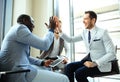 Happy successful multiracial business team giving a high fives gesture as they laugh and cheer their success. Royalty Free Stock Photo