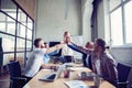 Happy successful multiracial business team giving a high fives gesture as they laugh and cheer their success. Royalty Free Stock Photo