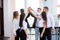 Happy successful multiracial business team giving a high fives gesture as they laugh and cheer their success. Business team