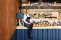 Happy successful new restaurant owner sitting on counter proud of her small business Royalty Free Stock Photo