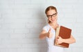 Happy successful student girl with book showing thumbs up