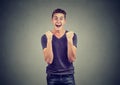 Happy successful student man winning, fists pumped celebrating success Royalty Free Stock Photo