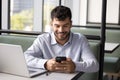 Happy successful young Arab freelance worker using digital gadgets