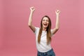 Happy successful young woman with smiling,shouting and celebrating success over pink background Royalty Free Stock Photo