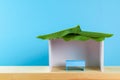 Happy Sukkot. A hut made of paper covered with leaves on a blue background. Copy the space.