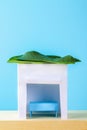 Happy Sukkot. A hut made of paper covered with leaves on a blue background. Copy the space.