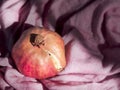 Happy Sukkot, New Year, Shanah Tovah concept : Pomegranate alone on pink cloth texture background with sharp light, strong shadows