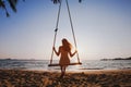 Happy summer beach holidays, beautiful girl relaxing on swing