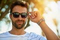 Happy, sunglasses and portrait of a man in an outdoor park while on a summer vacation, adventure or holiday. Smile