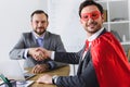 happy super businessman in mask and cape shaking hands with businessman