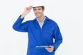 Happy supervisor wearing hard hat while holding clip board