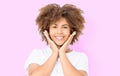 Happy suprised shocked excited girl face with afro curly hair. Young dark skin woman isolated on pink background. African american Royalty Free Stock Photo